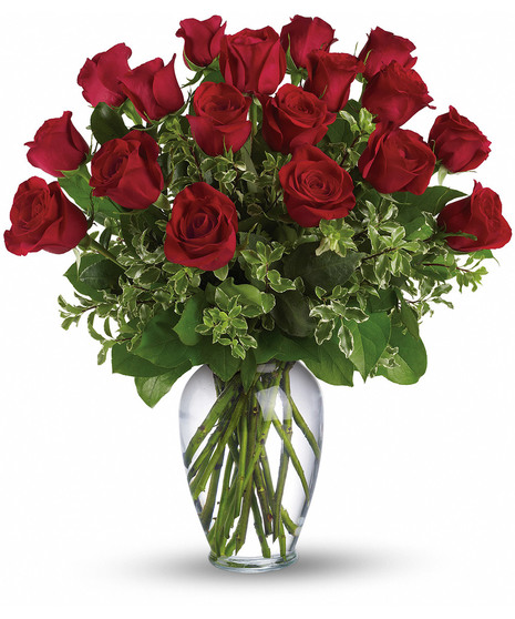 One dozen long stemmed red roses in a clear glass vase