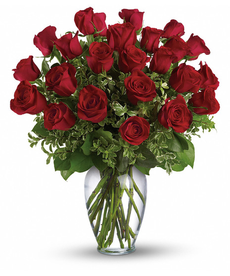 One dozen long stemmed red roses in a clear glass vase