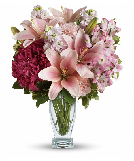 Lilies, hydrangea and stock arranged in a clear glass vase
