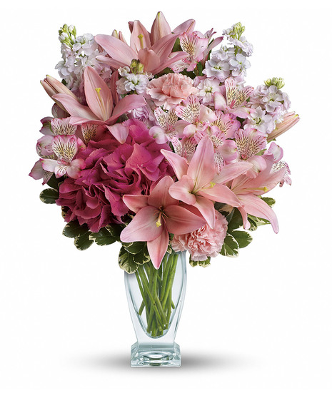 Lilies, hydrangea and stock arranged in a clear glass vase
