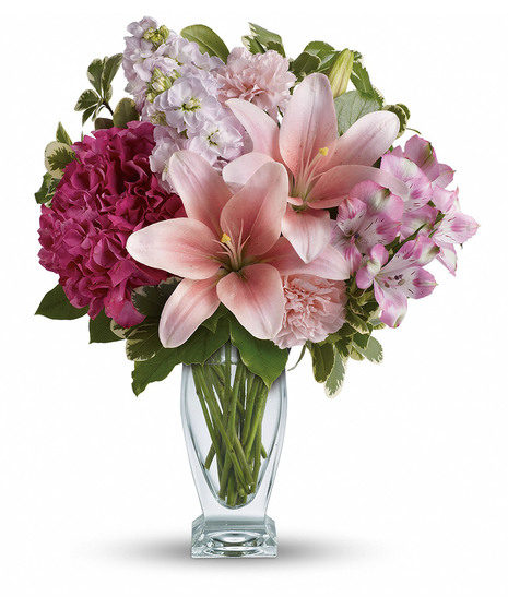 Lilies, hydrangea and stock arranged in a clear glass vase