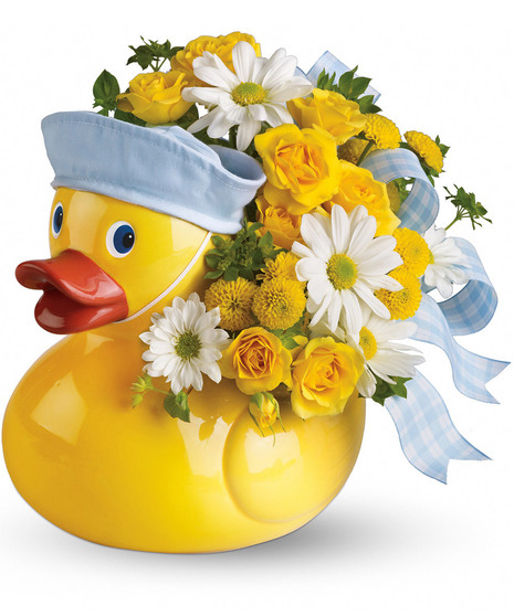 Charming duck container filled with yellow and white flowers and topped with a blue bow