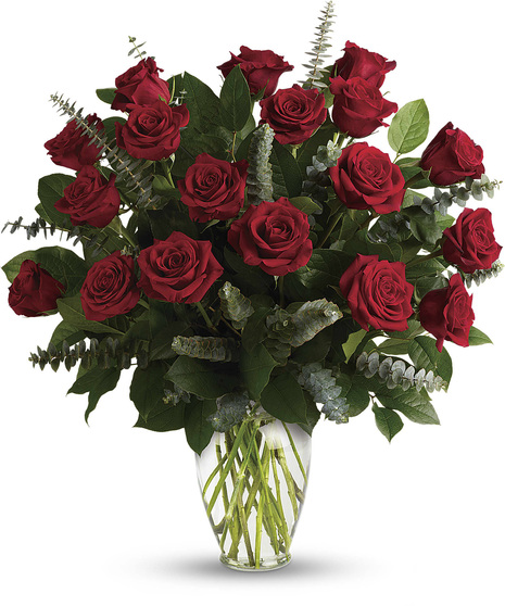 One dozen roses presented with greenery in a clear glass vase
