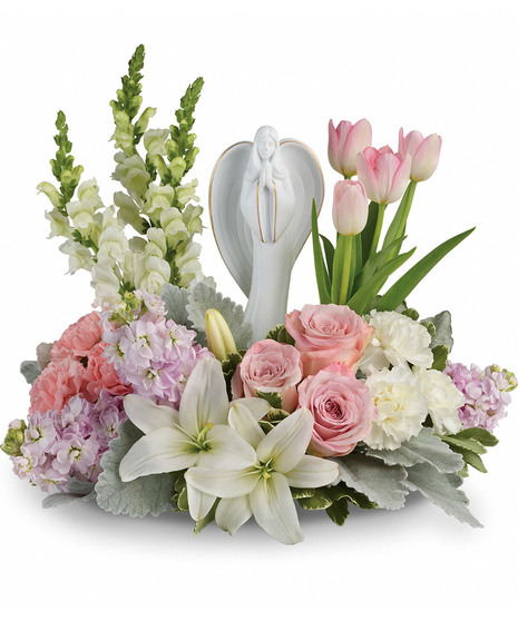 Angel sculpture surrounded by roses, lilies ind tulips in shades of pink and white
