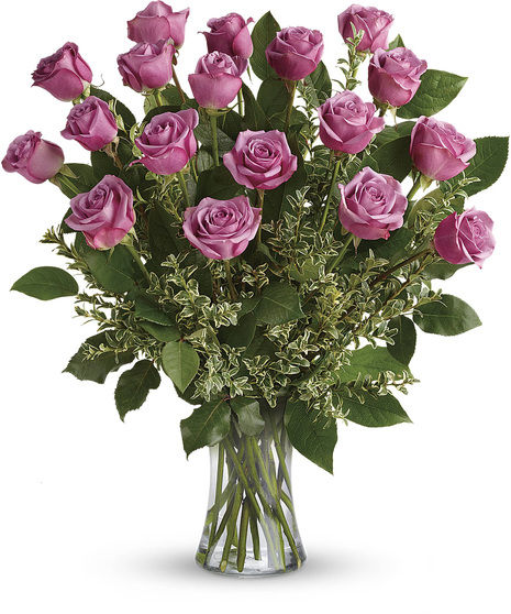 One dozen lavender roses and greenery in a clear glass vase