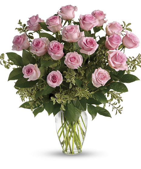 One dozen pink roses and greenery in a clear glass vase